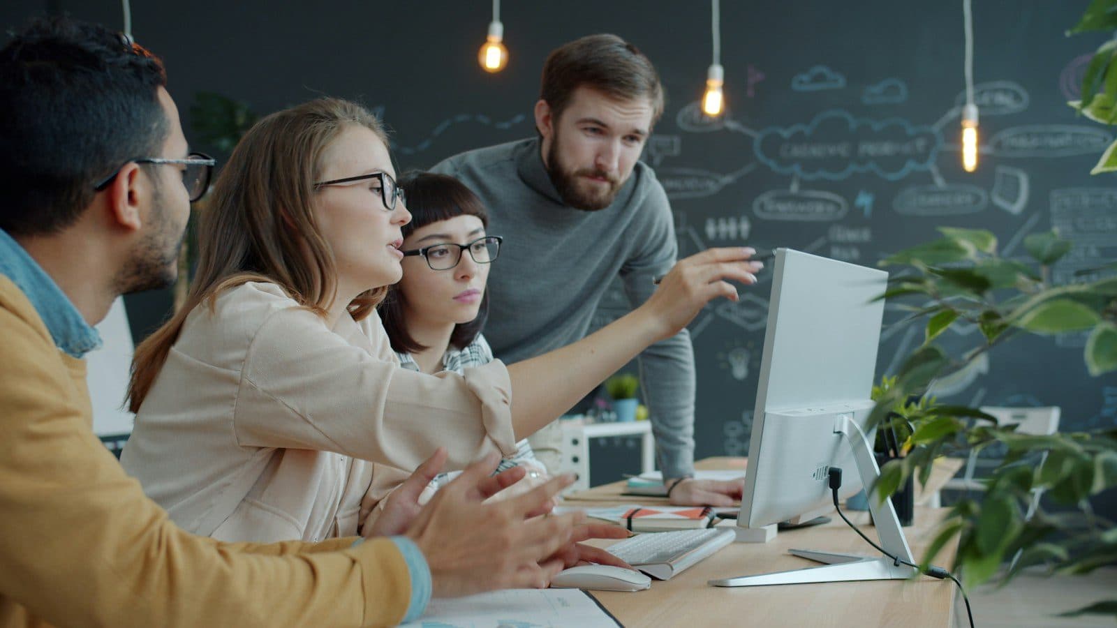 A team collaborating around a computer